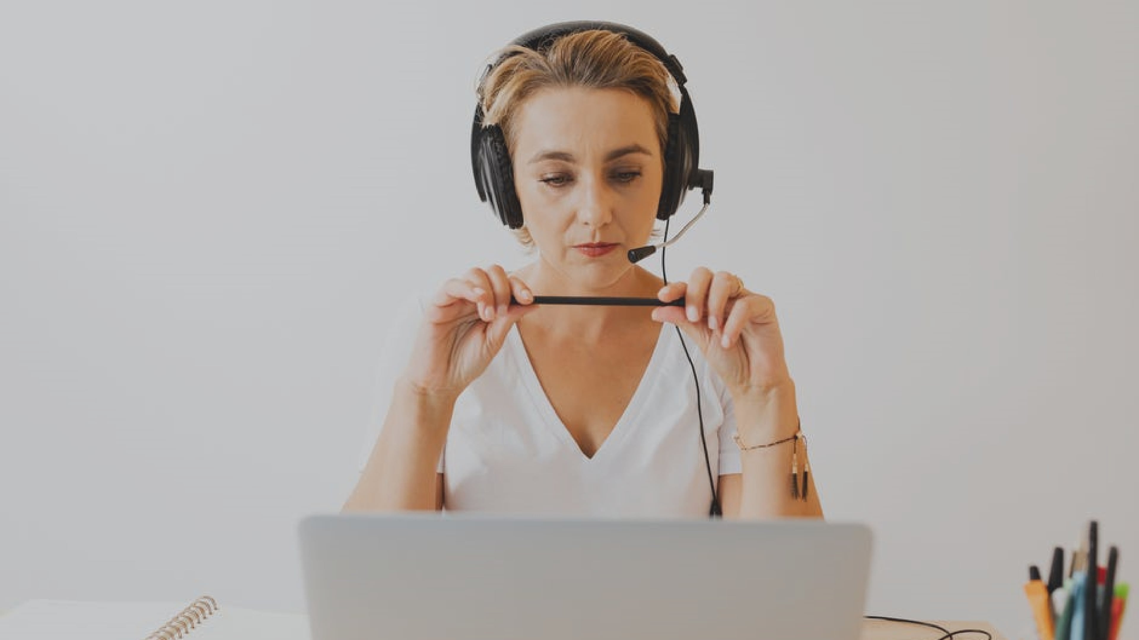 Customer care agent speaking with a customer on her headset and working on her computer